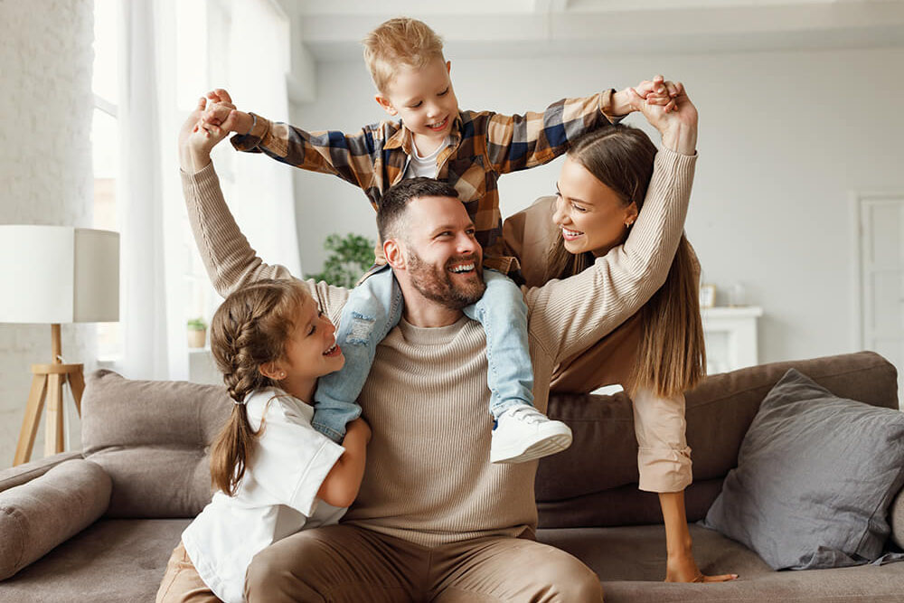 Happy family mother father and kids at home on couch